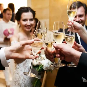 skleničky na sekt svatebčané si připíjejí na oslavu ženicha a nevěsty<br />